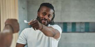 Save It; Don’t Waste It – Tip No. 3 Guy with oral hygiene tool standing in bathroom